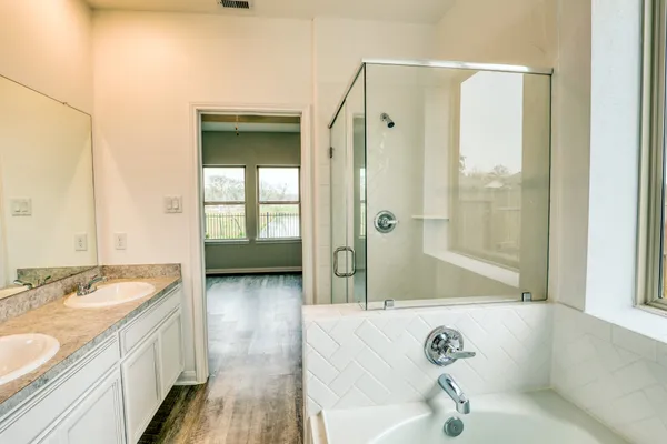 a bathroom with a tub sink and mirror