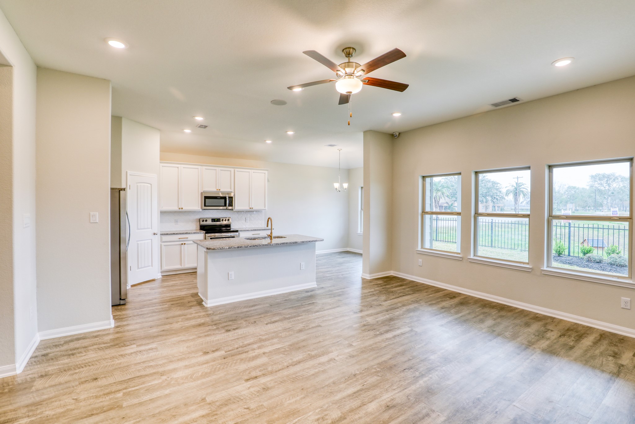 201 Bryan Way Angleton, TX 77515 - Photo 25 of 38 a large kitchen with stainless steel appliances kitchen island a large counter top and a wooden floor