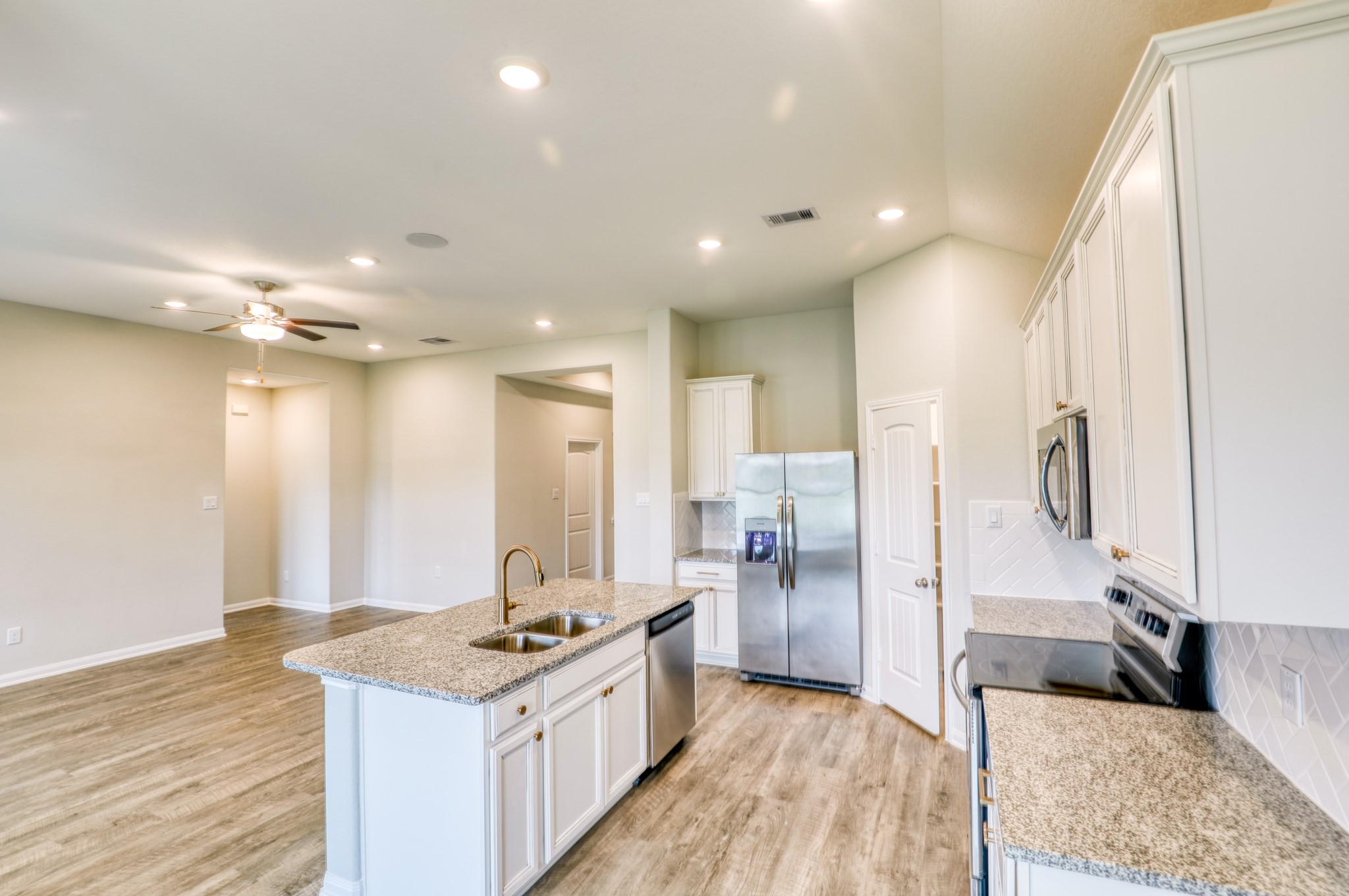 201 Bryan Way Angleton, TX 77515 - Photo 30 of 38 a large kitchen with stainless steel appliances kitchen island granite countertop a sink and a refrigerator