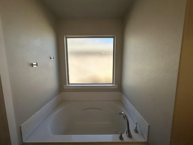 a bath tub sitting in a bathroom next to a window