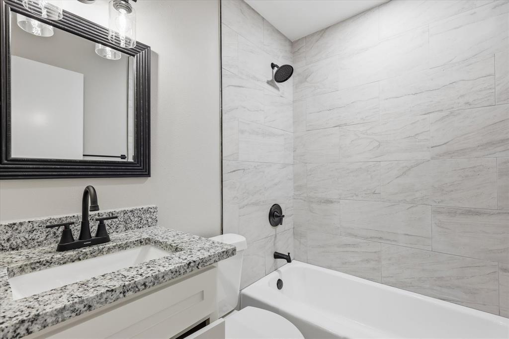 857 Twilight Trail Grapevine, TX 76051 - Photo 30 of 35 Bathroom featuring a white vanity with granite-style countertop, undermount sink, and matte black faucet