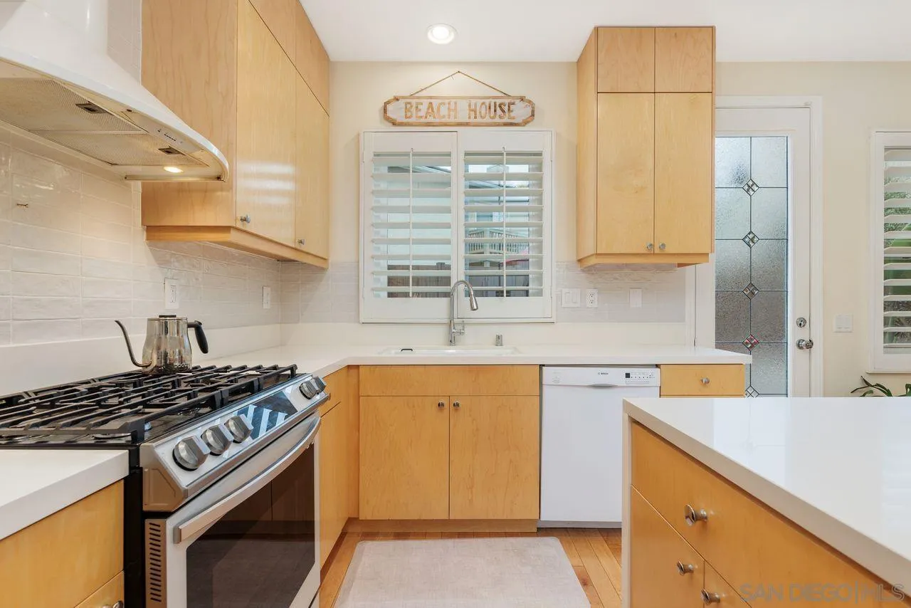 7390 Seafarer Place Carlsbad, CA 92011 - Photo 11 of 41 a kitchen with a sink stove top oven and cabinets