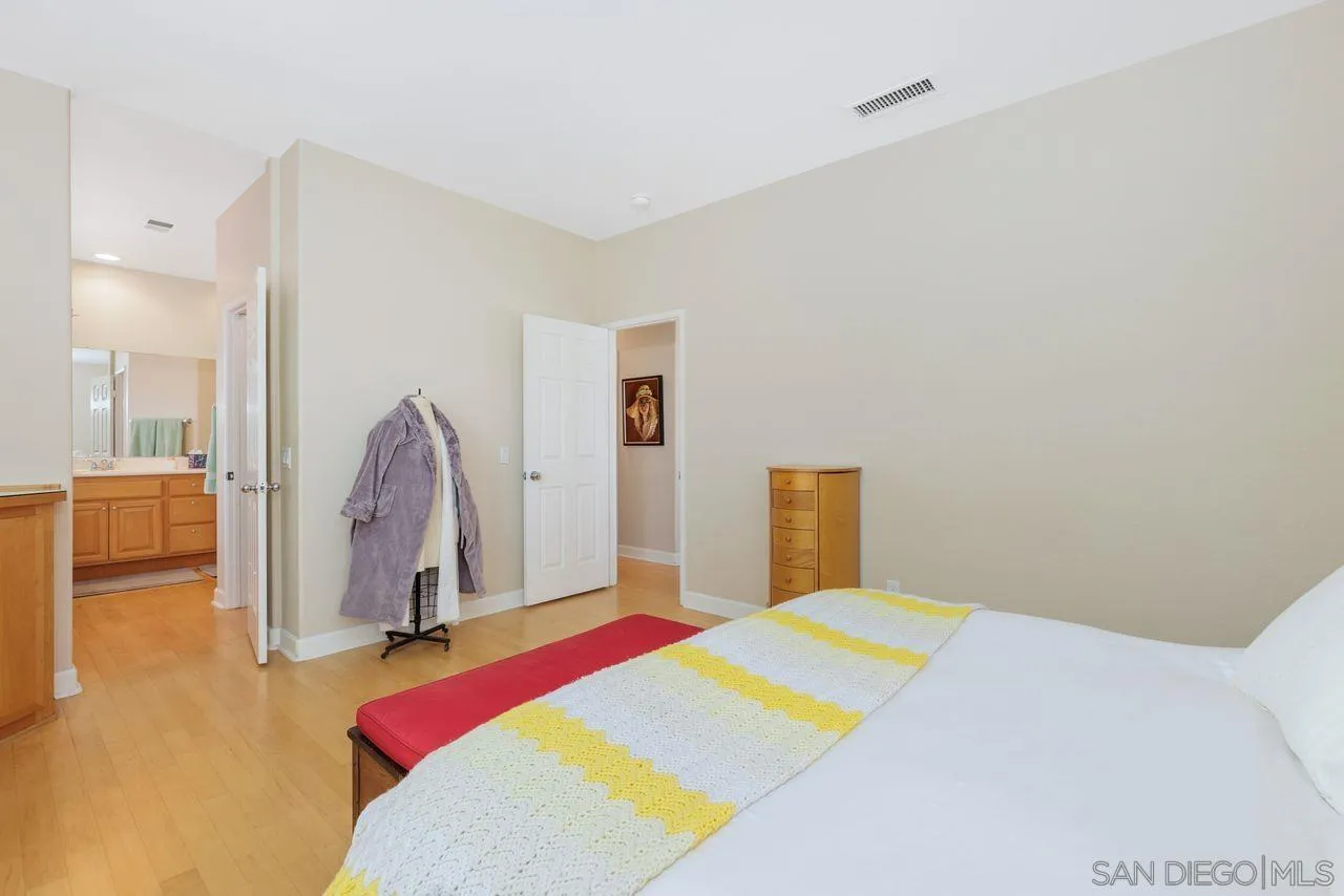 7390 Seafarer Place Carlsbad, CA 92011 - Photo 19 of 41 a bedroom with a bed dresser and a large mirror