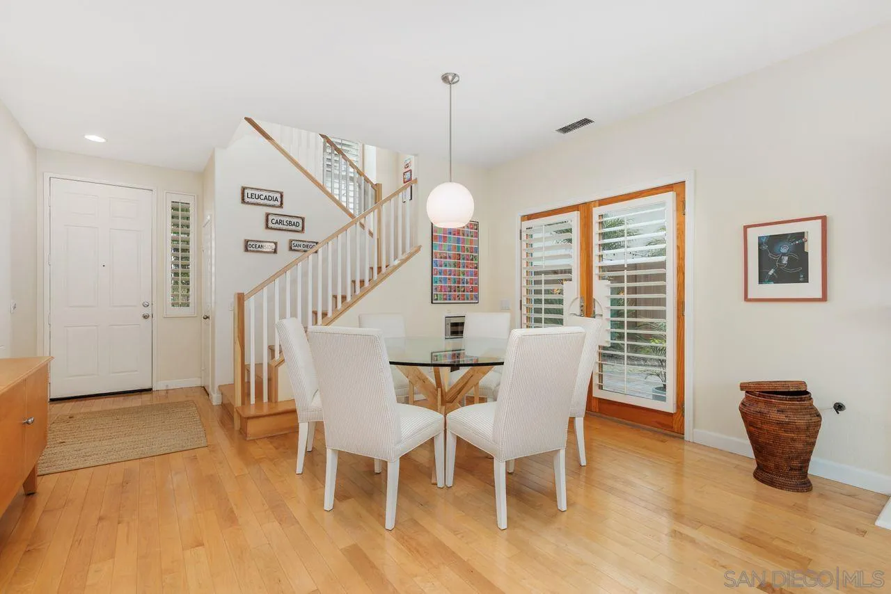 7390 Seafarer Place Carlsbad, CA 92011 - Photo 7 of 41 a dining room with furniture a chandelier and wooden floor