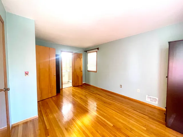 a view of a room with wooden floor and a window