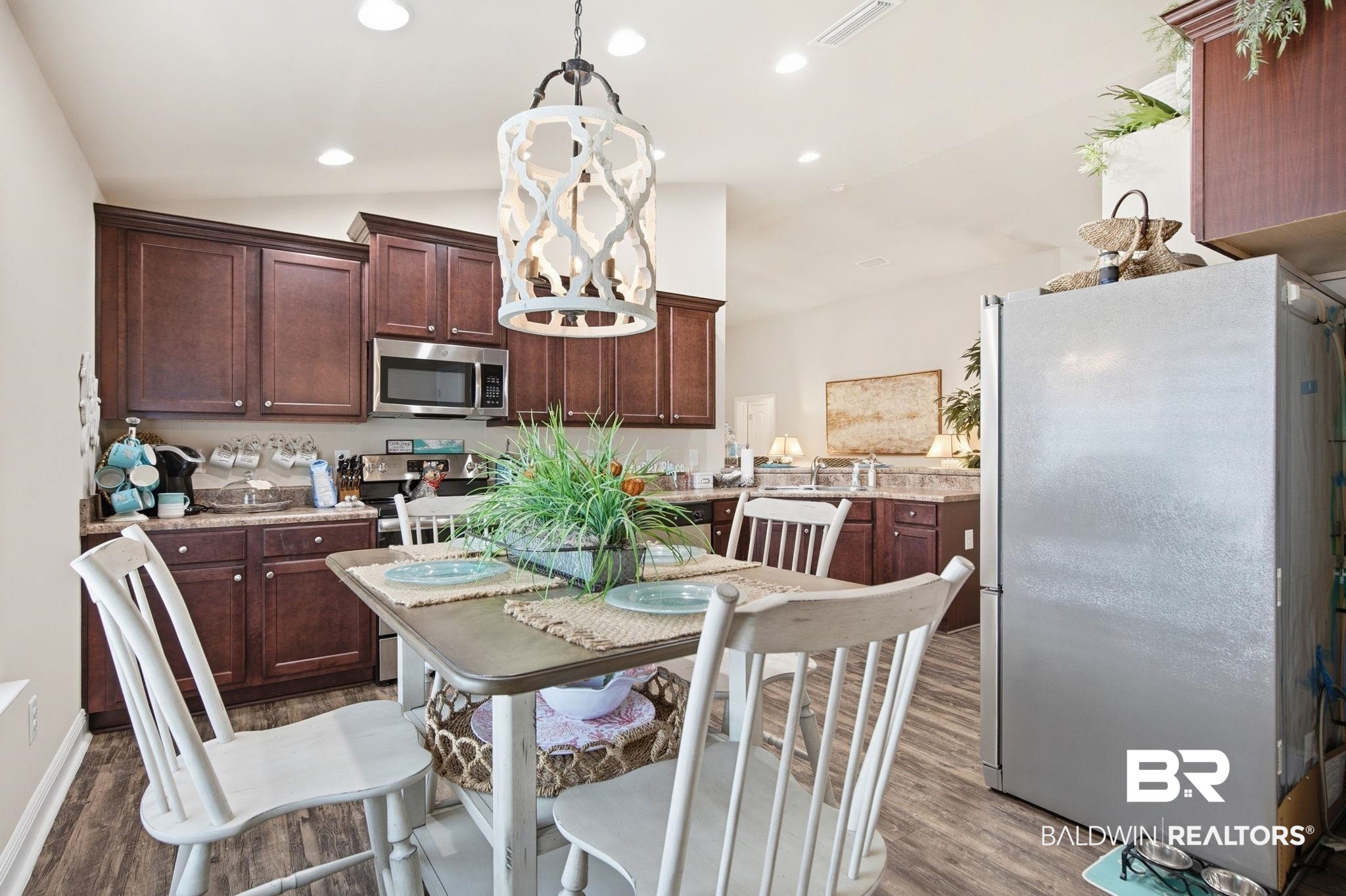 22596 Respite Lane Foley, AL 36535 - Photo 15 of 34 Kitchen with stainless steel appliances, dark wood finished floors, vaulted ceiling, dark wood finish cabinetry, and suspended lighting