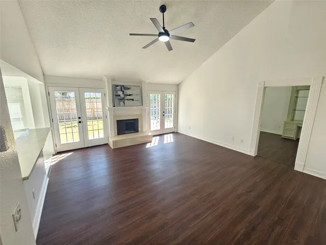 a view of an empty room with window and wooden floor