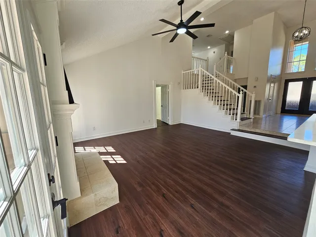 a view of a livingroom with wooden floor and stairs