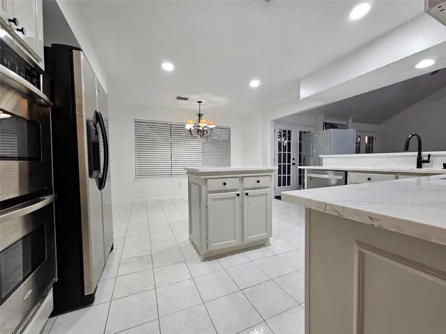 a kitchen with stainless steel appliances a refrigerator sink and cabinets