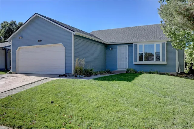 a front view of house with yard and trees around