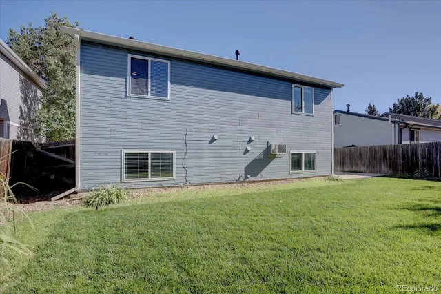 a view of a backyard with potted plants and wooden fence