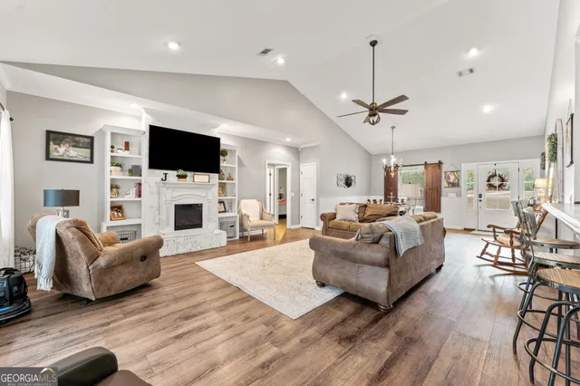 a living room with furniture a flat screen tv and a fireplace