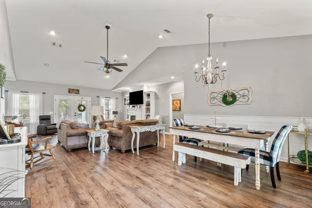 a living room with furniture kitchen view and a chandelier