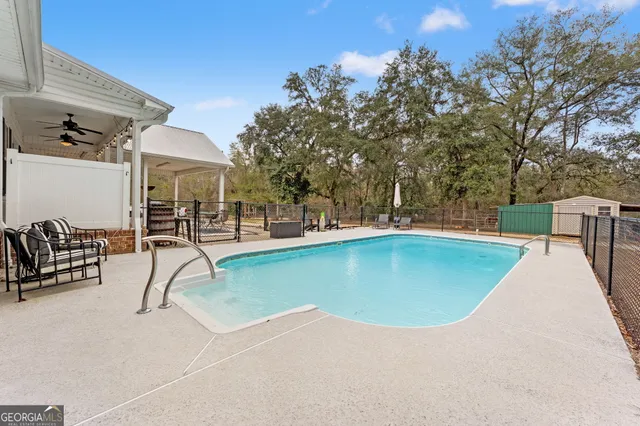 a view of a house with swimming pool and sitting area