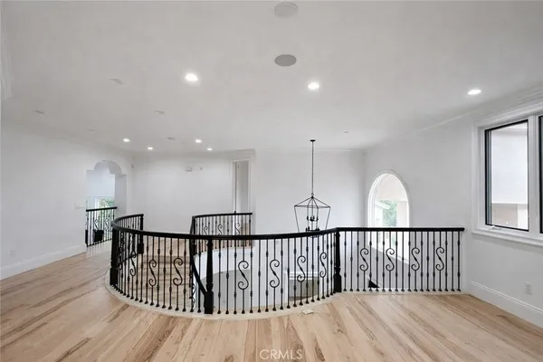 a view of staircase with lots of frames on wall and wooden floor