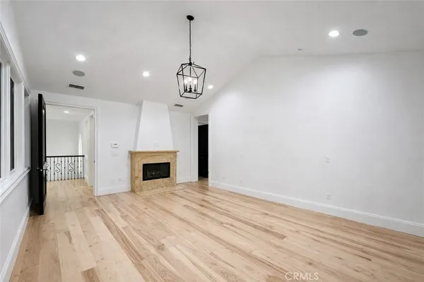 a view of a livingroom with a fireplace a chandelier a wooden table and chandelier