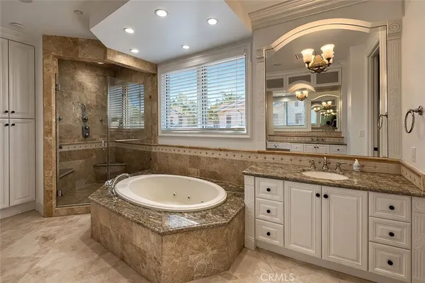 a bathroom with a granite countertop sink a toilet a mirror and window