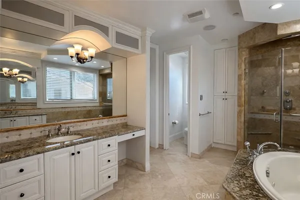 a bathroom with a granite countertop sink mirror and a bathtub