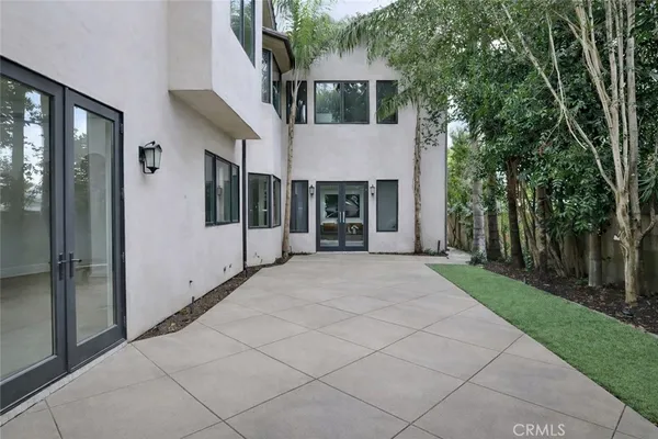 a view of house with backyard and glass windows