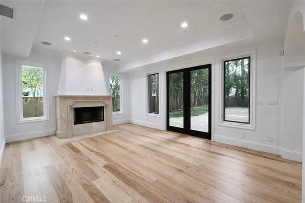 a view of an empty room with a fireplace and a window