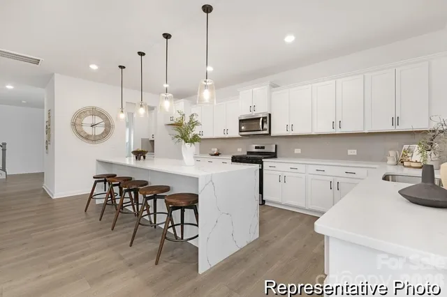 a kitchen with cabinets a sink a stove and wooden floor