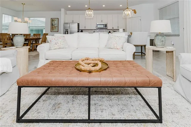 a living room with furniture and a dining table with kitchen view