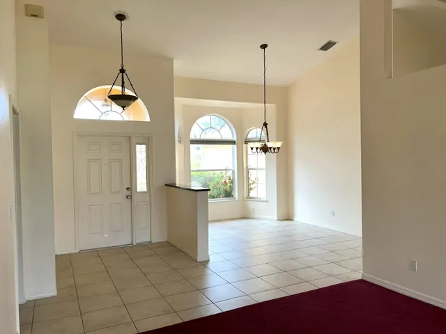 a view of a room with window wooden floor and front door