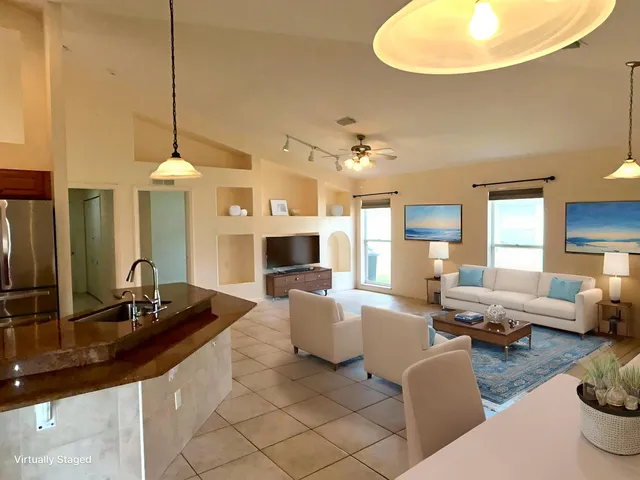 a living room with furniture a mirror and lamp