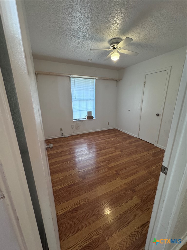 1301 North 10th Street Temple, TX 76501 - Photo 12 of 25 wooden floor in an empty room with a window