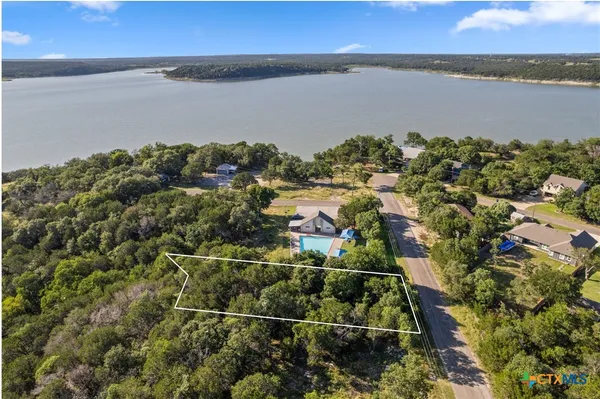 an aerial view of residential houses with outdoor space and lake view