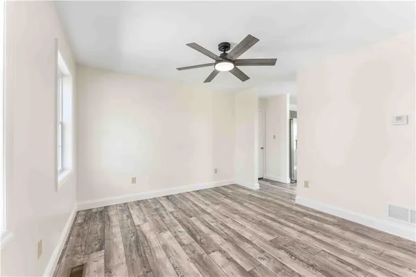 a view of a room with wooden floor and a ceiling fan