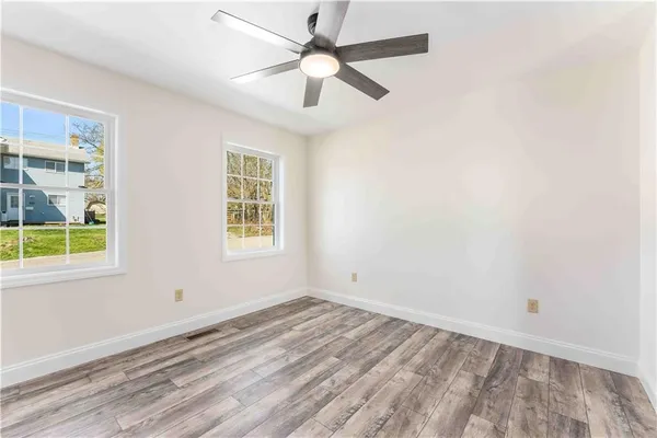 wooden floor in an empty room with a window
