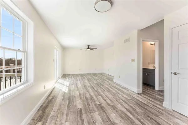 wooden floor in an empty room with a window