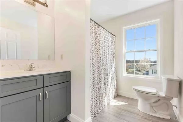 a bathroom with a sink toilet a mirror and shower