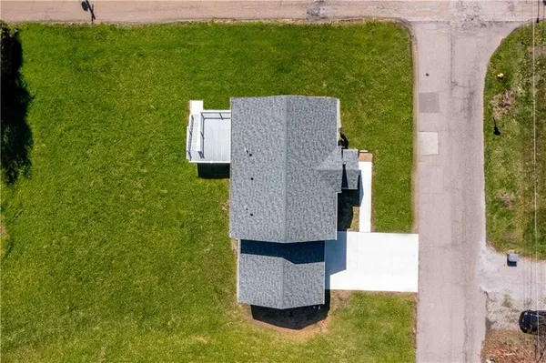an aerial view of a house with garden space and a car parked