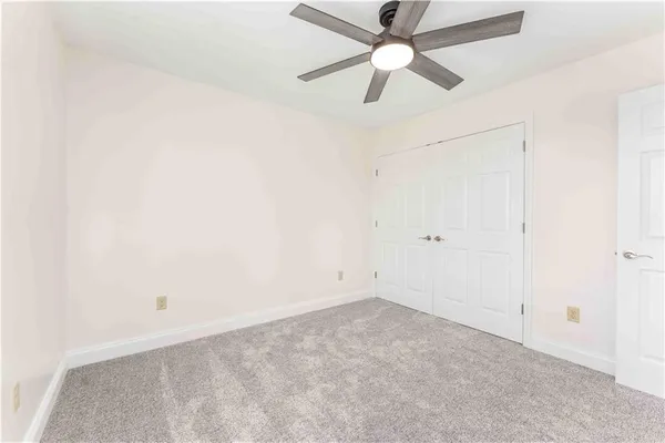 an empty room with a fan & a ceiling fan