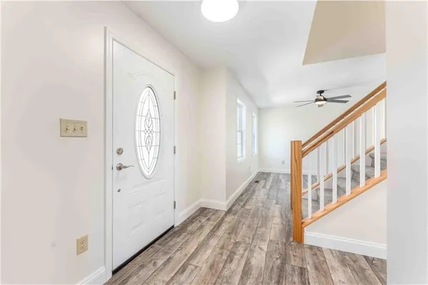 a view of a hallway with wooden floor and staircase