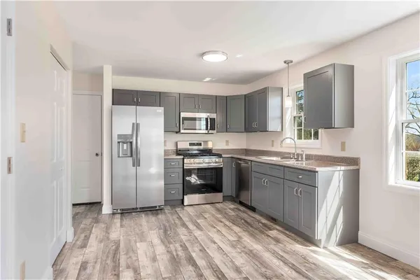 a kitchen with stainless steel appliances granite countertop a refrigerator and a stove top oven