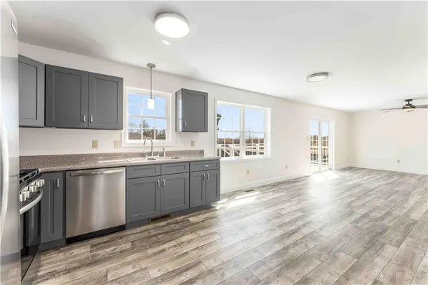 a kitchen with granite countertop a sink cabinets and wooden floor