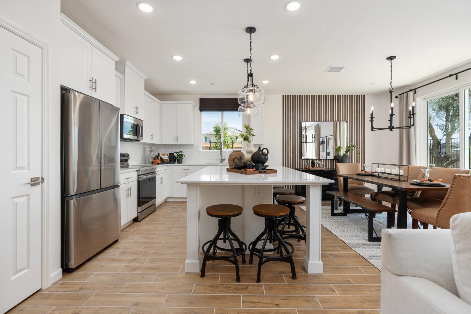 1601 Bloom Avenue Clovis, CA 93619 - Photo 8 of 28 a kitchen with stainless steel appliances kitchen island granite countertop a refrigerator a stove a sink a dining table and chairs with wooden floor