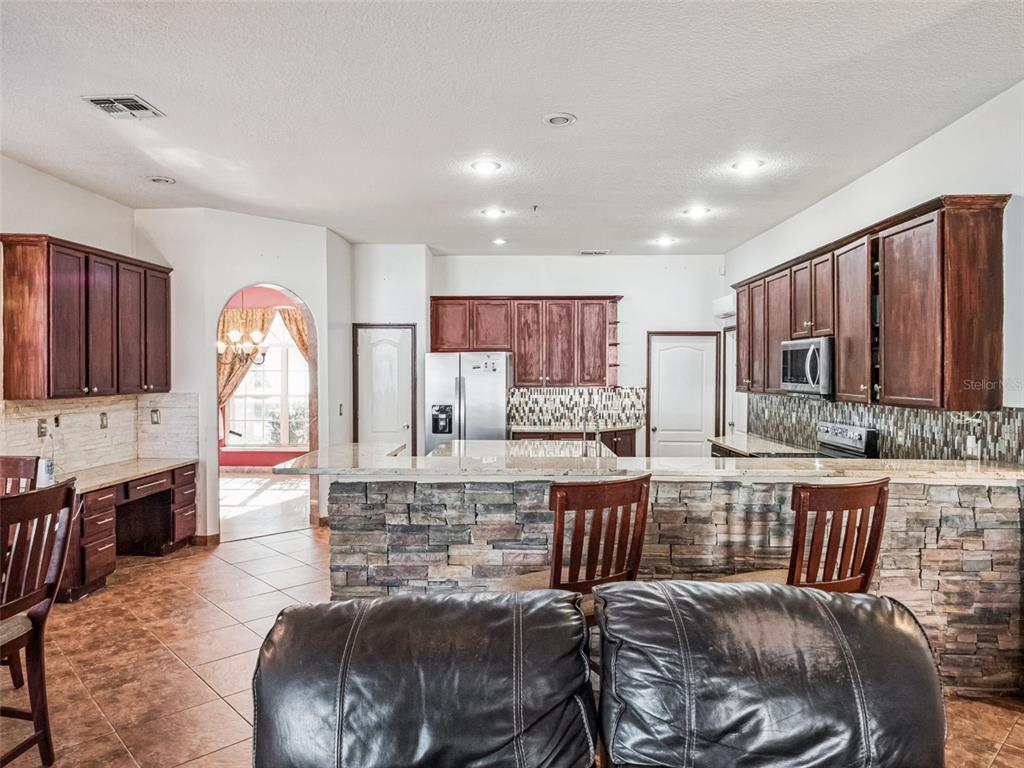 9101 Lake Coventry Court Gotha, FL 34734 - Photo 16 of 45 a living room with furniture a flat screen tv and kitchen view