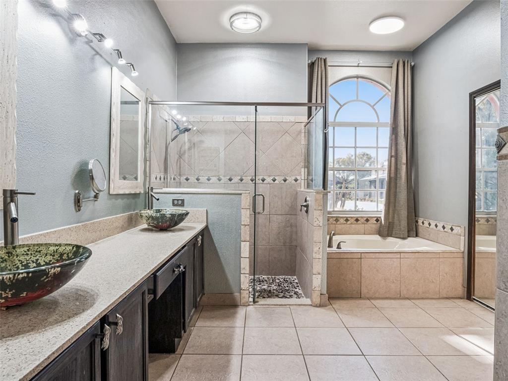 9101 Lake Coventry Court Gotha, FL 34734 - Photo 21 of 45 a bathroom with a tub sink and mirror