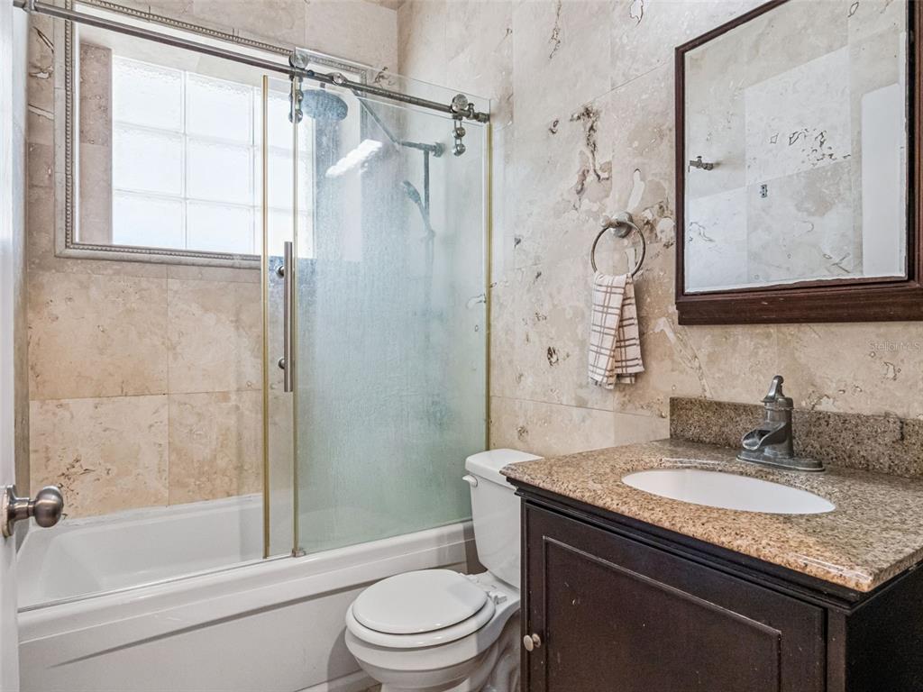 9101 Lake Coventry Court Gotha, FL 34734 - Photo 23 of 45 a bathroom with a granite countertop sink toilet and shower