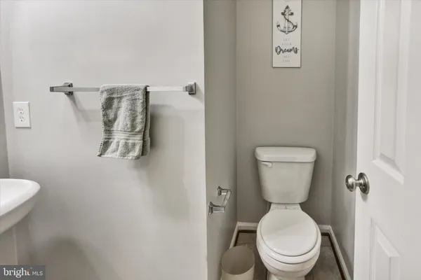 a white toilet sitting next to a white wall