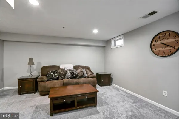 a living room with furniture and a air conditioner vent