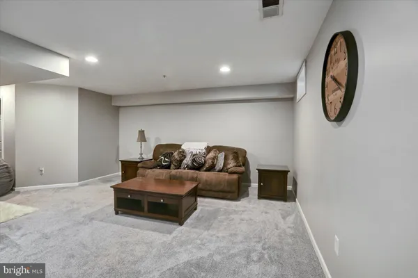 a living room with furniture and a mirror