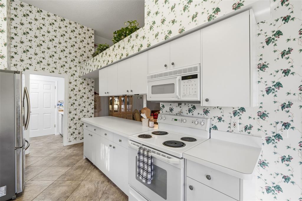 7354 Woodhollow Road Spring Hill, FL 34606 - Photo 17 of 47 a kitchen with a sink a stove and a refrigerator
