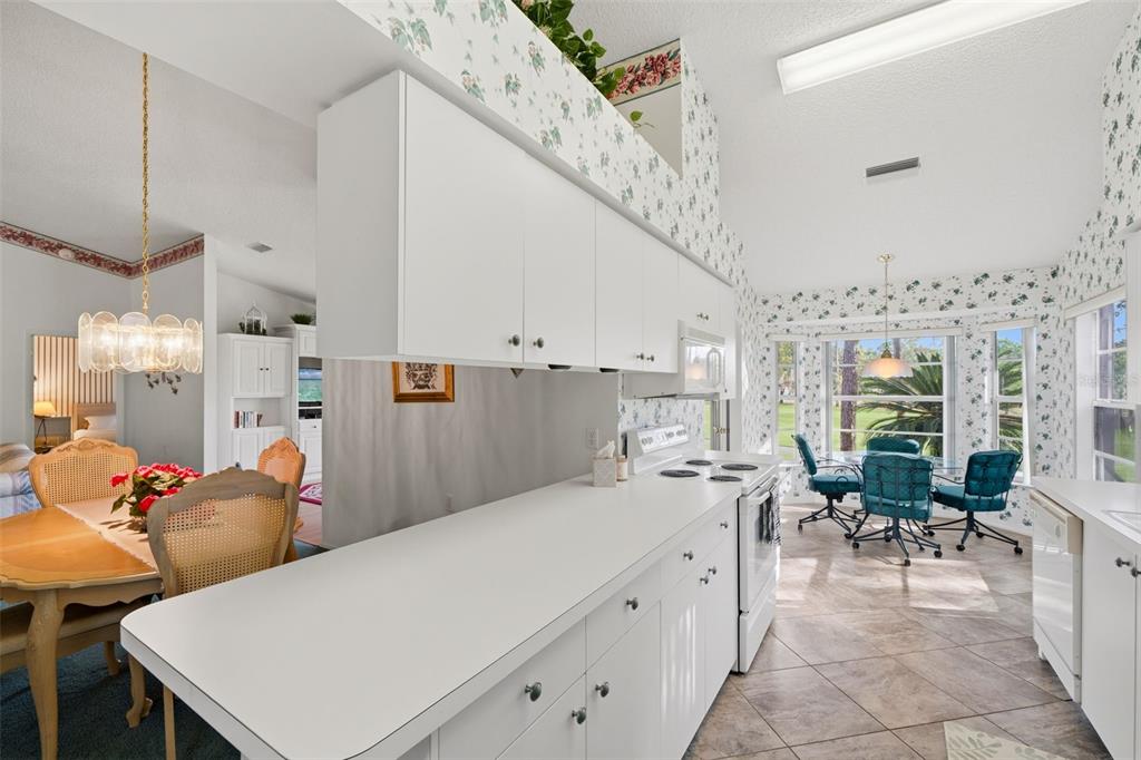 7354 Woodhollow Road Spring Hill, FL 34606 - Photo 18 of 47 a large white kitchen with a table and chairs