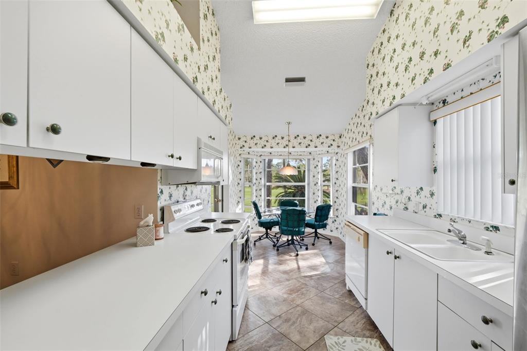 7354 Woodhollow Road Spring Hill, FL 34606 - Photo 19 of 47 a large white kitchen with a large window