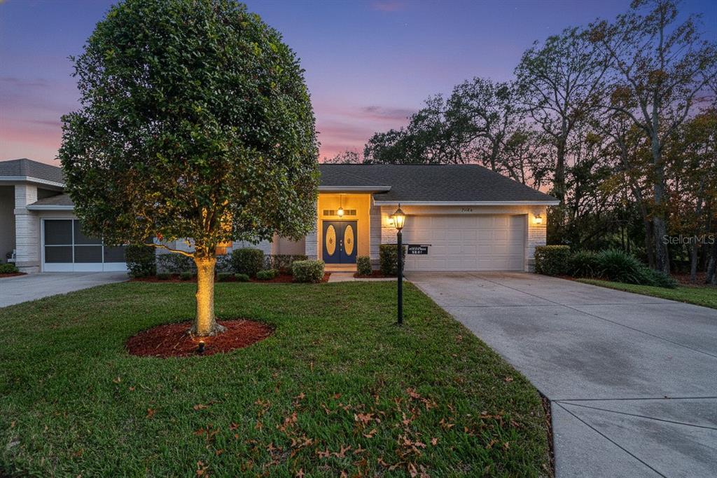 7354 Woodhollow Road Spring Hill, FL 34606 - Photo 2 of 47 a front view of a house with a yard and a tree